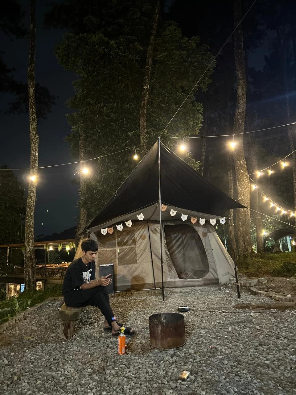 Peserta camping berpose di depan tenda dengan latar belakang area camping yang asri di Sentul.