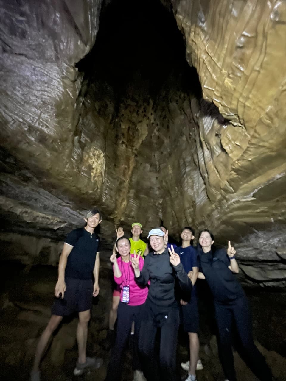 Dua orang peserta menikmati jernihnya air sungai sambil menunjuk ke arah tebing hijau.